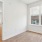 a room with a wood floor and a window with blinds