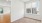a room with a wood floor and a window with blinds